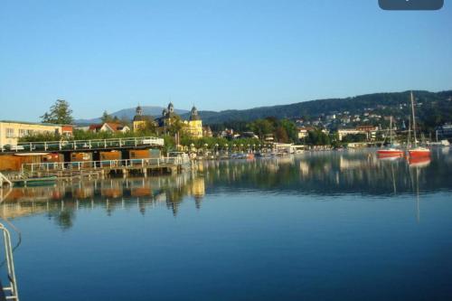 a large body of water with a town in the background at Strandhaus am Wörthersee in Velden am Wörthersee