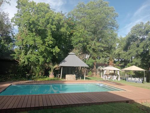 - une piscine dans une cour avec un kiosque dans l'établissement Majestic Manor Guesthouse & Coffee Shop, à Bloemfontein