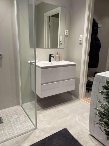 a bathroom with a white sink and a mirror at Downtown apartment high standard in Svolvær