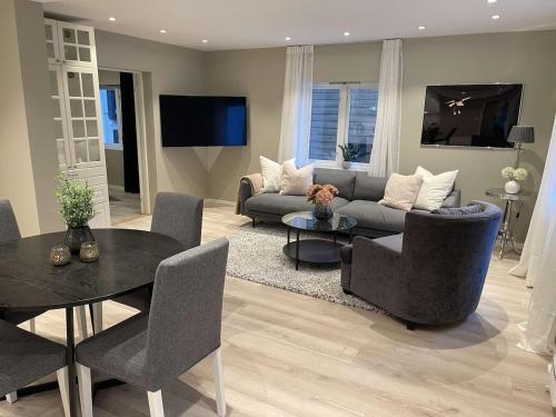 a living room with a couch and a table at Downtown apartment high standard in Svolvær