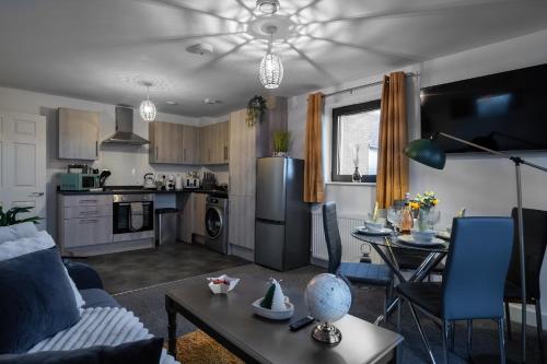 a kitchen and living room with a couch and a table at Affordable 1 & 2 Bed Apartments in Slough, Great Heathrow Location in Colnbrook