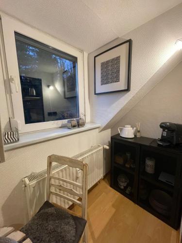a staircase with a window and a chair in a room at Modernes 1-Raum-Apartment in Dresden