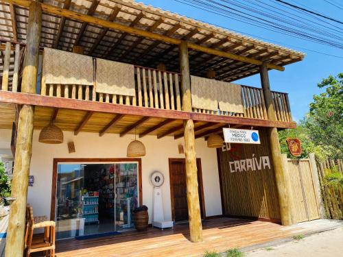 un edificio con terraza y tienda en Vila Bahia suítes, en Caraíva