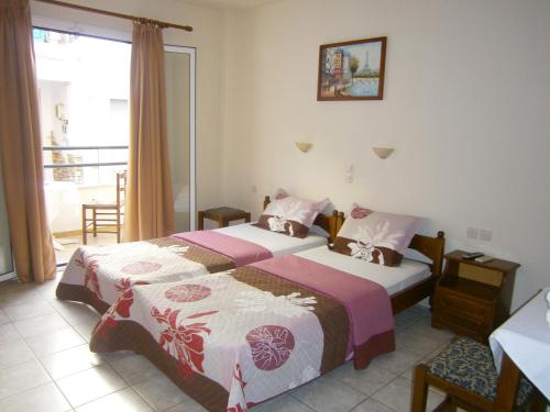 a hotel room with two beds and a balcony at Pansion Chrisa in Skiathos Town