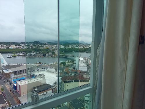 a view of a city from a window at Kitnet da Maria in Guarapari