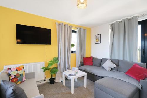 a living room with a couch and a tv at Affordable 1 & 2 Bed Apartments in Slough, Great Heathrow Location in Colnbrook