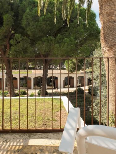 a white bench sitting in front of a fence at Hostal Empúries in L'Escala