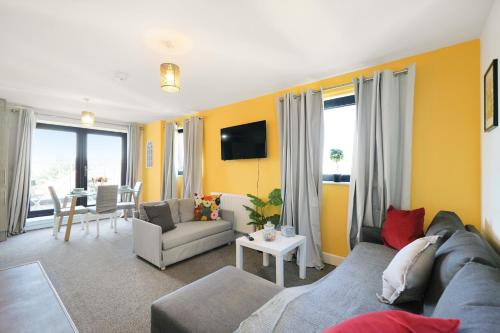 a living room with a couch and a table at Affordable 1 & 2 Bed Apartments in Slough, Great Heathrow Location in Colnbrook