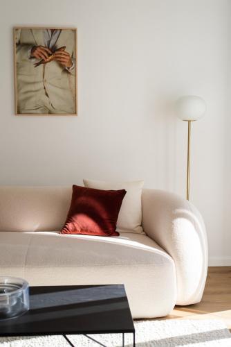 a living room with a white couch with a red pillow at The Haus Santa Bárbara I Lisbon in Lisbon