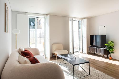 a living room with a couch and a tv at The Haus Santa Bárbara I Lisbon in Lisbon
