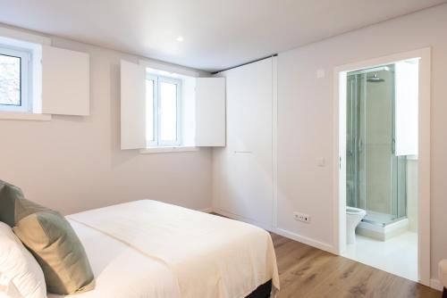 a white bedroom with a bed and a toilet at The Haus Santa Bárbara I Lisbon in Lisbon