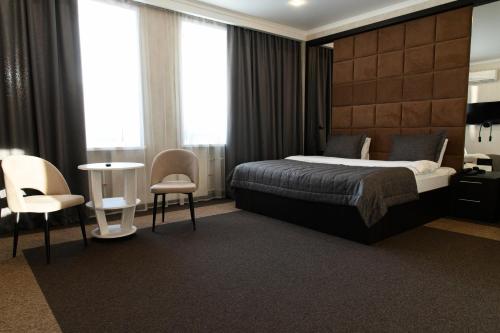 a hotel room with a bed and a table and chairs at Meridian in Karagandy
