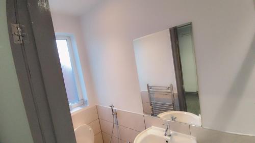 a bathroom with two sinks and a mirror at En-Suite Double-Bedroom in the Heart of Eccles Manchester Perfect for Short Stays BH5 in Manchester