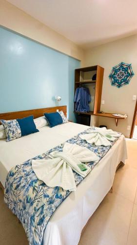 a bedroom with a large bed with blue and white sheets at Pousada Cantinho da Praia in Paraty