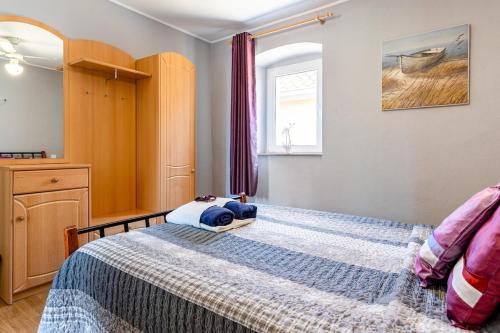 a bedroom with a bed and a window at Old Stone House with private Swimming Pool in Solin