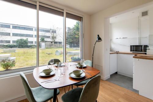 une salle à manger avec une table et des chaises et une grande fenêtre dans l'établissement Geranimus Loire Quay, à Paris