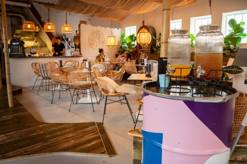a restaurant with tables and chairs and a bar at Ouder-kind B&B Droomzacht - Natuurkamer in Epe