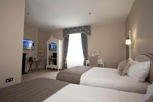 a hotel room with two beds and a window at Owston Hall Hotel in Doncaster