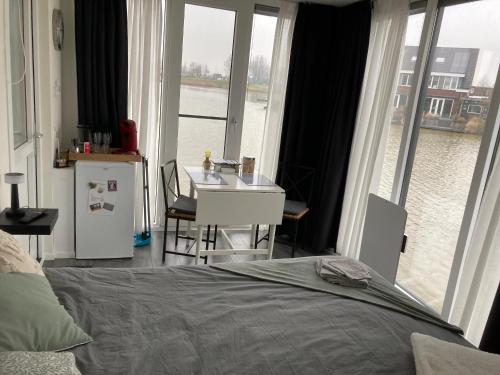a bedroom with a bed and a view of the water at Bed & Breakfast ‘t Westergouwertje in Gouda
