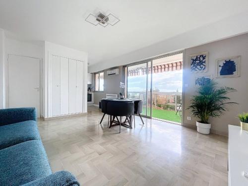 un salon avec un canapé bleu et une table dans l'établissement Juan les pins Studio détente Vacances & Mer, à Juan-les-Pins