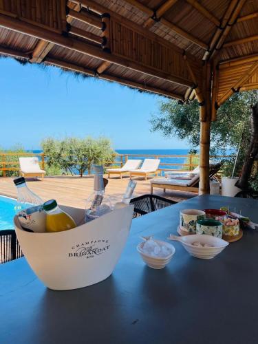 - une table avec un bol de nourriture et une bouteille de vin dans l'établissement Villa Cala d Oro Vue mer Piscine et Crique privée, à Sari-Solenzara