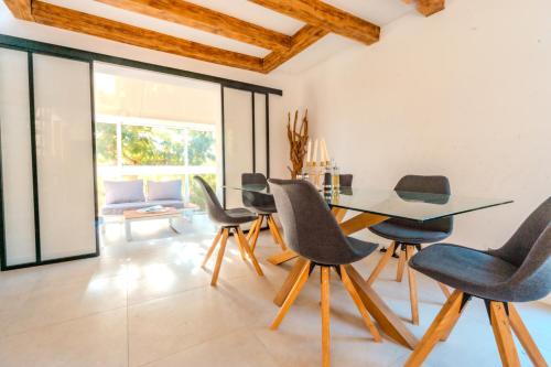 une salle à manger avec une table et des chaises en verre dans l'établissement La villa de Mara, à Canet