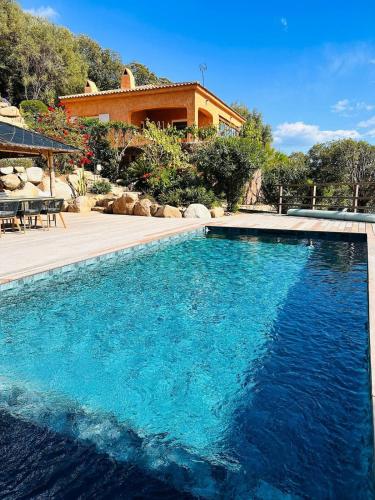 une piscine devant une maison dans l'établissement Villa Cala d Oro Vue mer Piscine et Crique privée, à Sari-Solenzara