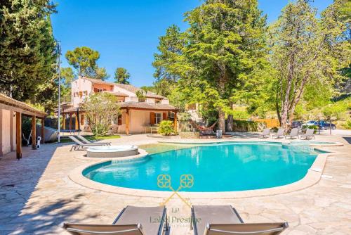 une piscine avec des chaises et une maison dans l'établissement La Bastide du Vallon, à La Ciotat
