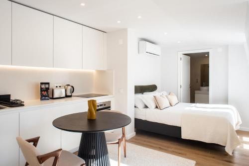 a bedroom with a bed and a table and a kitchen at The Haus Santa Bárbara I Lisbon in Lisbon
