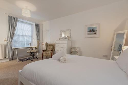 a white bedroom with a white bed and a desk at Fleming Place Haven in St. Andrews