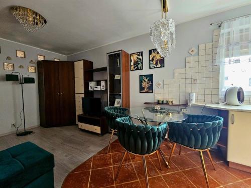 a living room with a glass table and blue chairs at GLAMOUR Apartment in Poznań
