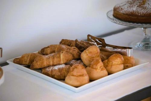 a plate of pastries on a table with a cake at B&B Il Palazzotto di Luca Luxury Suites in Lecce