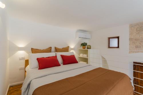 a bedroom with a large bed with red pillows at Santaló B&B in Bitonto