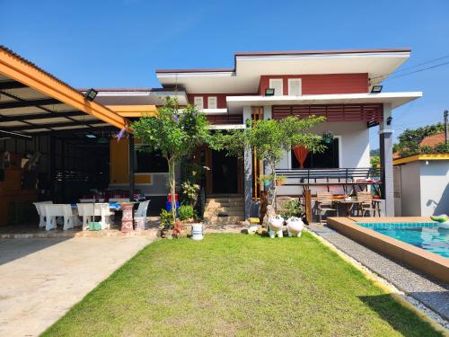 a house with a backyard with a swimming pool at Puree Poolvilla Sattahip in Sattahip