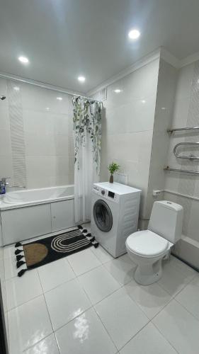 een badkamer met toilet en wasmachine bij БЦ Алматы, иманова-валиханова in Astana