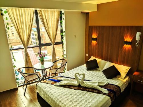 a bedroom with a bed and a table and a window at Velvet residence in Cusco