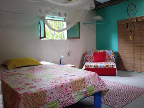 a bedroom with a bed and a chair at Casa Refugio LA TEBAIDA in Mocoa