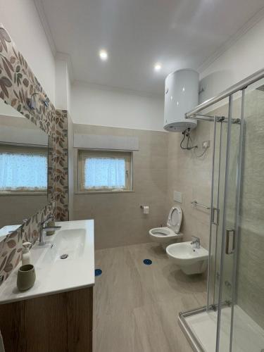 a bathroom with two sinks and a shower and a toilet at Casa Franco in Sant'Agnello