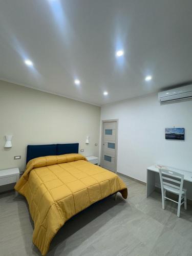 a bedroom with a yellow bed and a desk at Casa Franco e Michela in Sant'Agnello