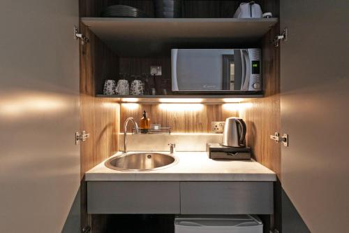 a kitchen with a sink and a microwave at London Paddington Apartments in London