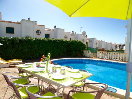 a white table and chairs next to a swimming pool at Vital by Check-in Portugal in Albufeira