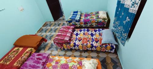 a group of blankets and pillows on a bed at Shanti Rental And Dormitory in Kāthgodām