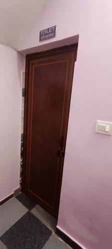 a brown door with a sign on top of it at Shanti Rental And Dormitory in Kāthgodām