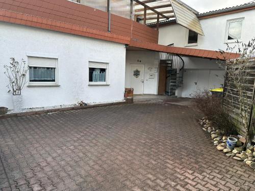 リューデスハイムにあるRüdesheim Monteurwohnungの白い建物前の煉瓦造りの私道