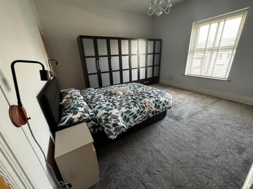 a bedroom with a bed with a black headboard at Double-Bed Manchester Close To Bolton City Centre C2 in Little Hulton