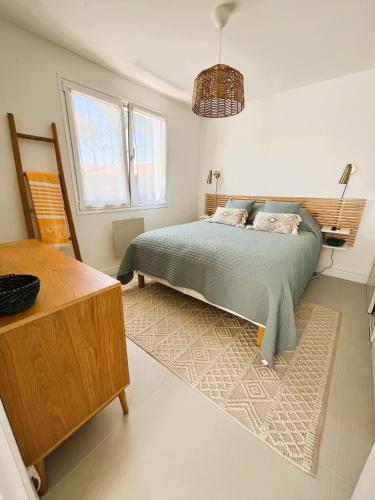 - une chambre avec un lit, une table et une fenêtre dans l'établissement Nouveau! Villa Bahia, Piscine chauffée, Plage à 400m, à Vieux-Boucau-les-Bains