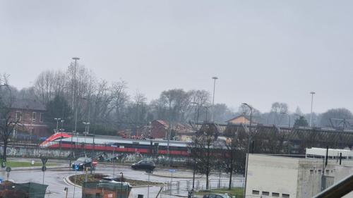 a train on a bridge over a parking lot at Rogoredo - 10 min-Linate airport 100 m from the metro in Milan