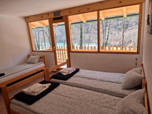 a bedroom with two bunk beds and a window at Rafting kamp HEDERA in Foča