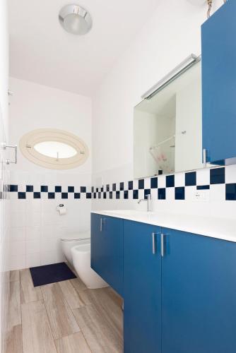 a bathroom with blue cabinets and a sink and a mirror at Villa dei Cavallucci Marini in Capoliveri