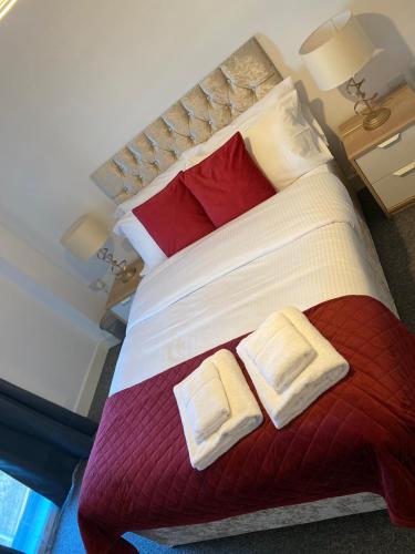 a bedroom with a large bed with two towels on it at Affordable 1 & 2 Bed Apartments in Slough, Great Heathrow Location in Colnbrook